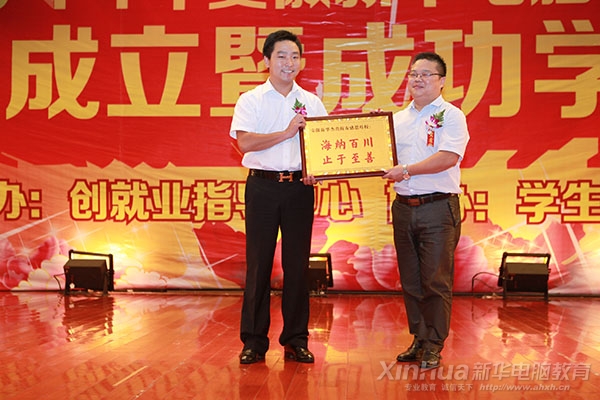向安徽新華專修學院院長吳元紅贈送牌匾,以表感恩之心的劉亮